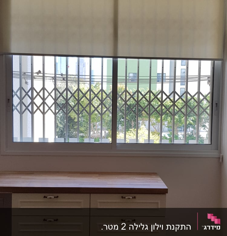 וילון גלילה בהיר על חלון עם סורגים